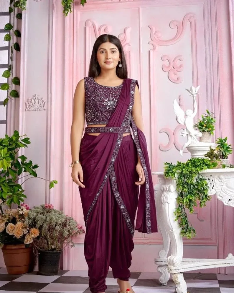 Woman in a dhoti-style sari made of georgette, paired with a halter-neck crop top and statement earrings.